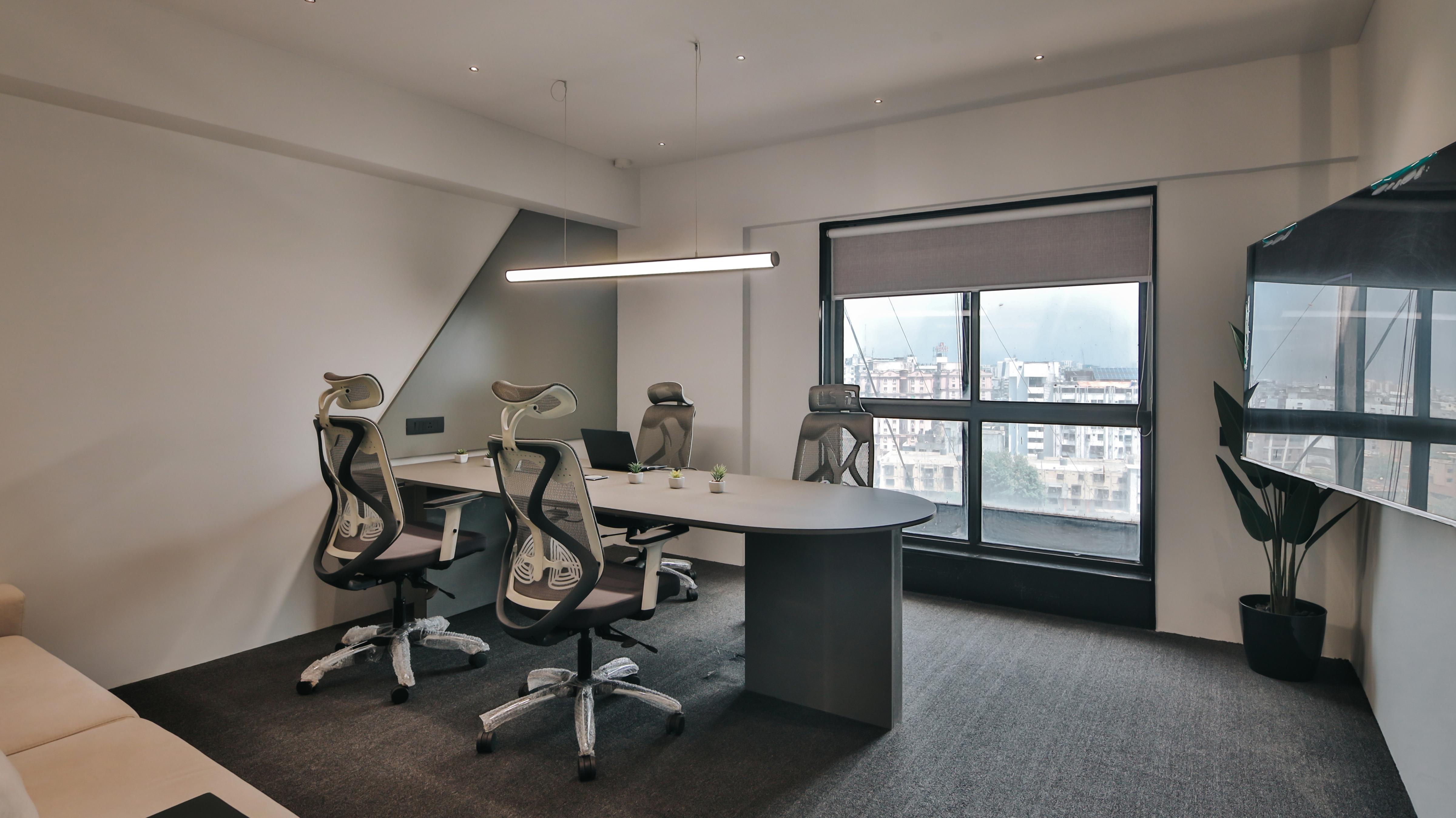 Fully furnished private office cabin with meeting table, ergonomic chairs, natural light, and city view, ideal for small teams and startups.