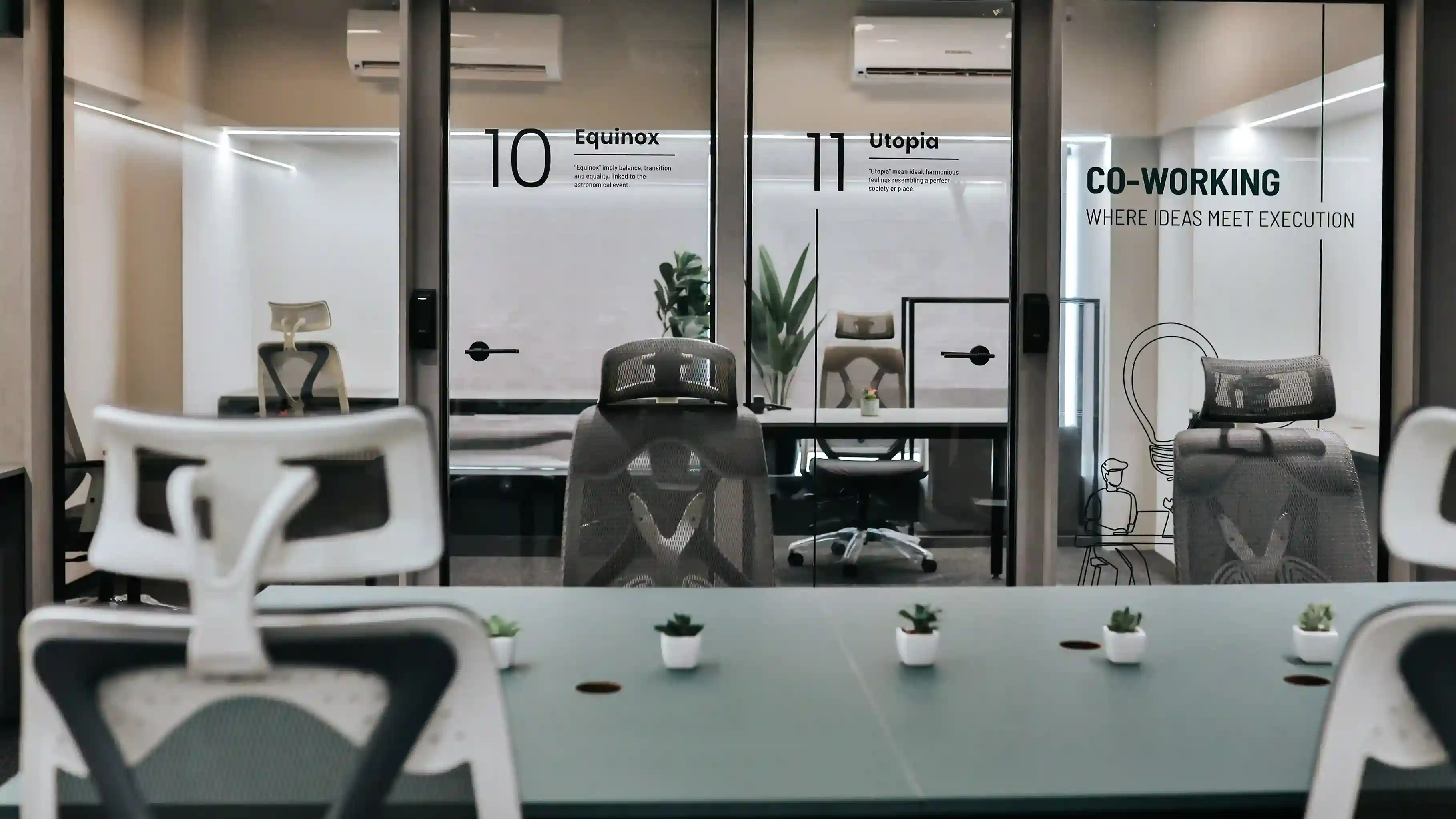 Coworking space with hot desks and private glass meeting rooms designed for productivity and comfort