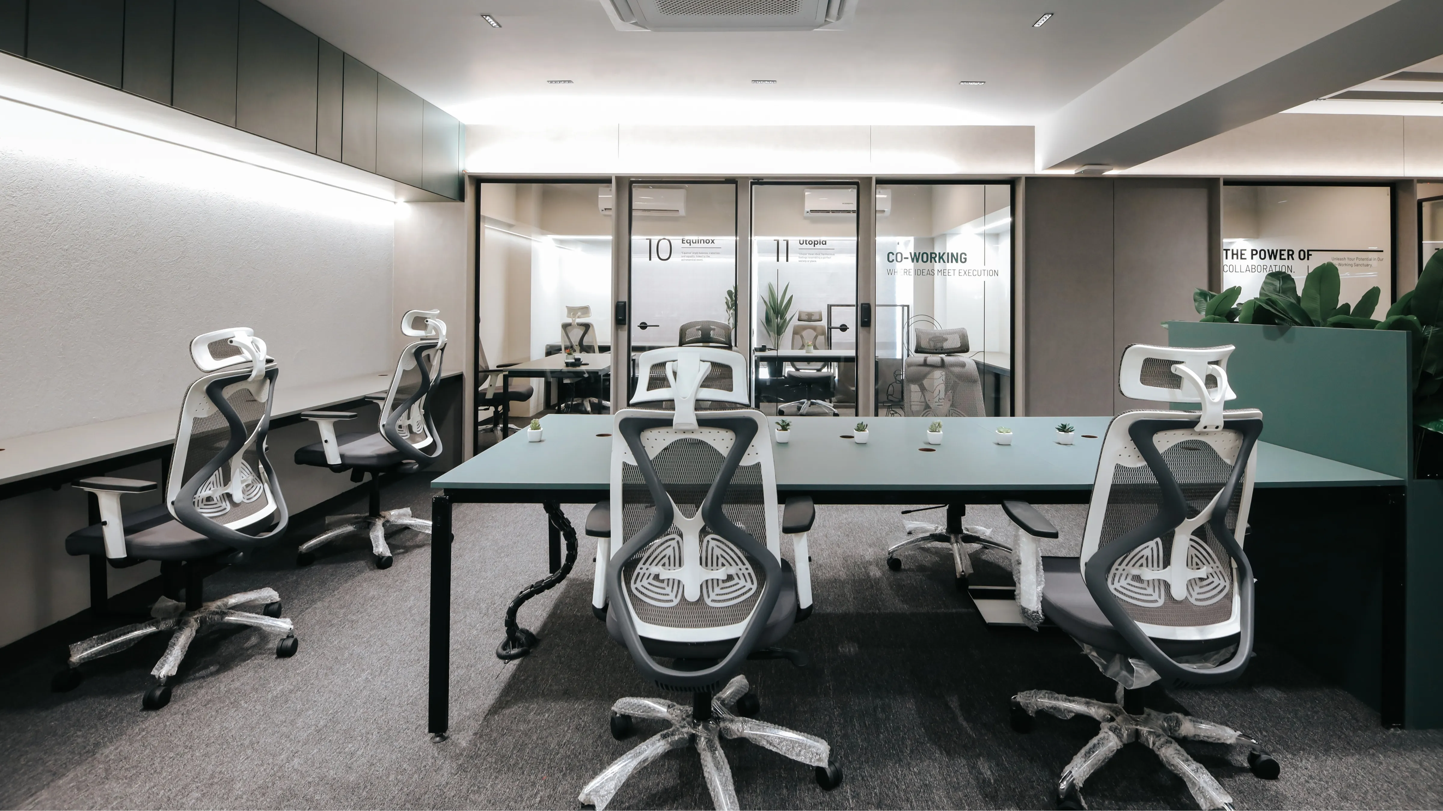 Contemporary coworking office with ergonomic chairs, shared desks, and private glass meeting rooms in a professional workspace environment