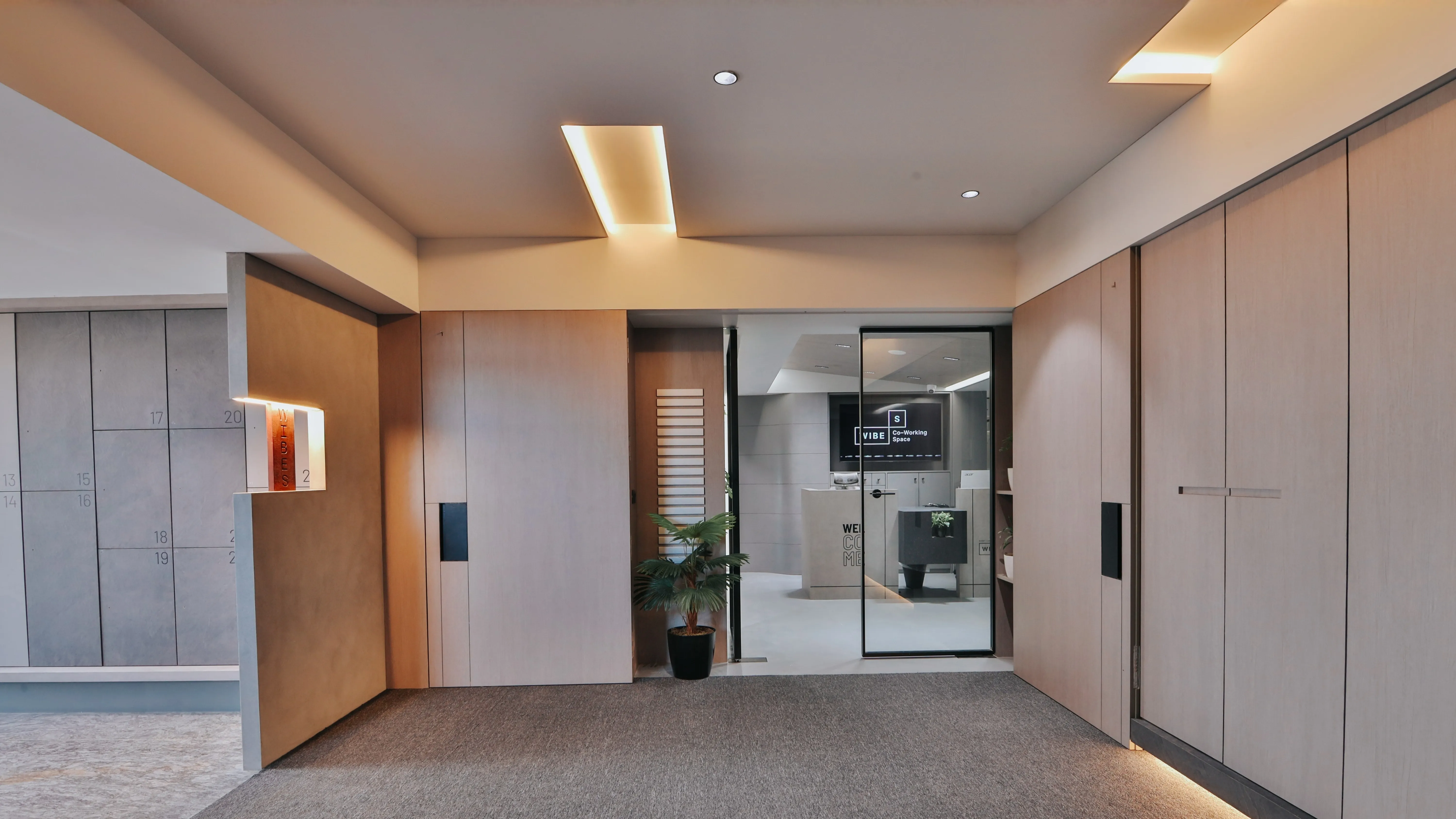 Modern virtual office reception area with a professional entrance, glass door meeting room, warm lighting, and minimalist corporate interior design